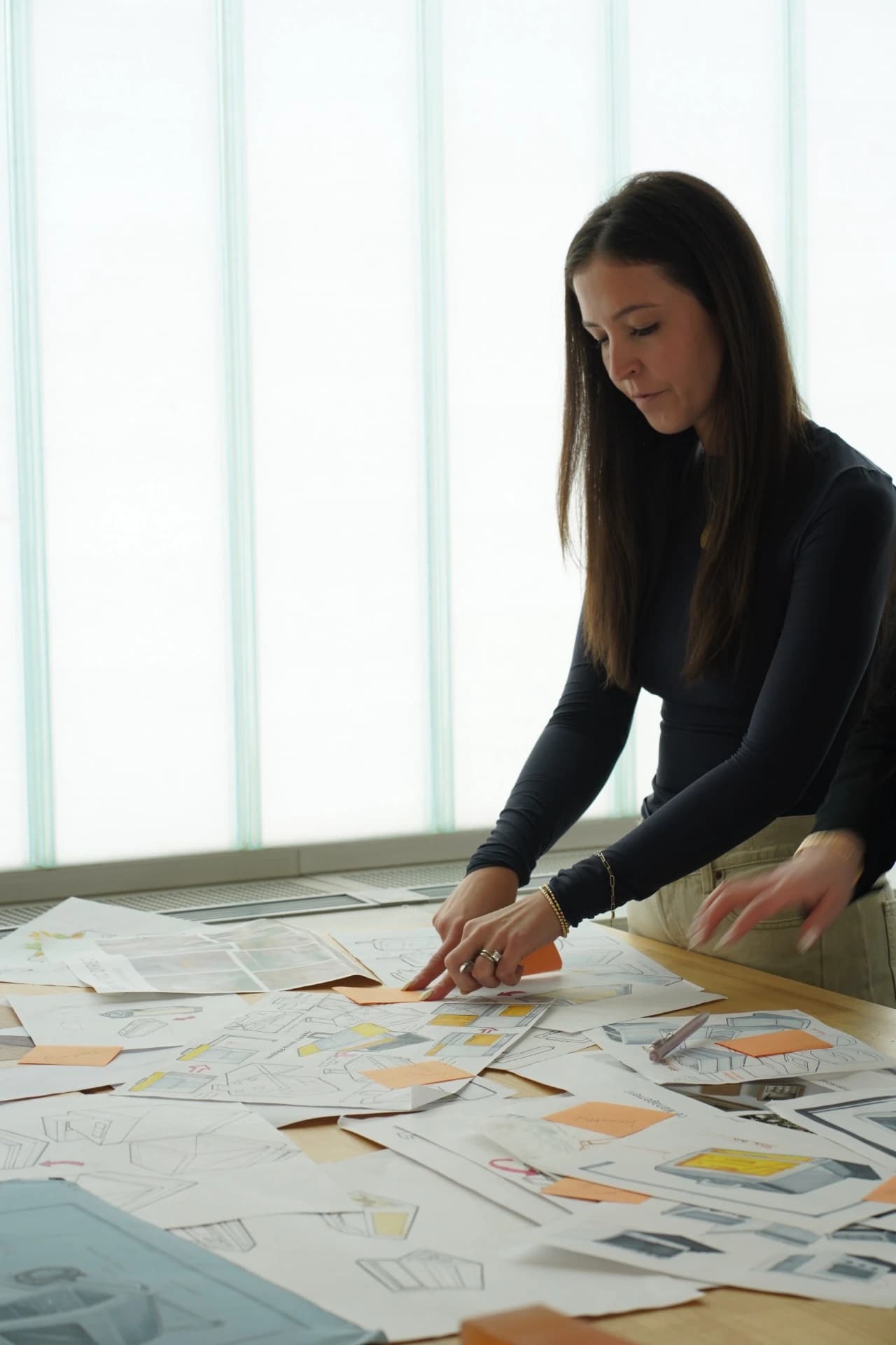 Maddi Firminger reviewing product design sketches at a worktable